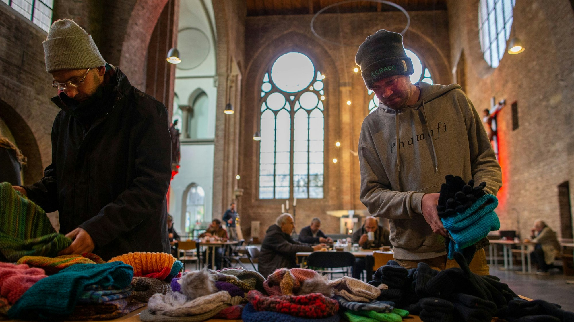 Über gespendete handgestrickte Wintersachen freuen sich Jörg (50) und Andreas (34) in der Gubbiokirche.