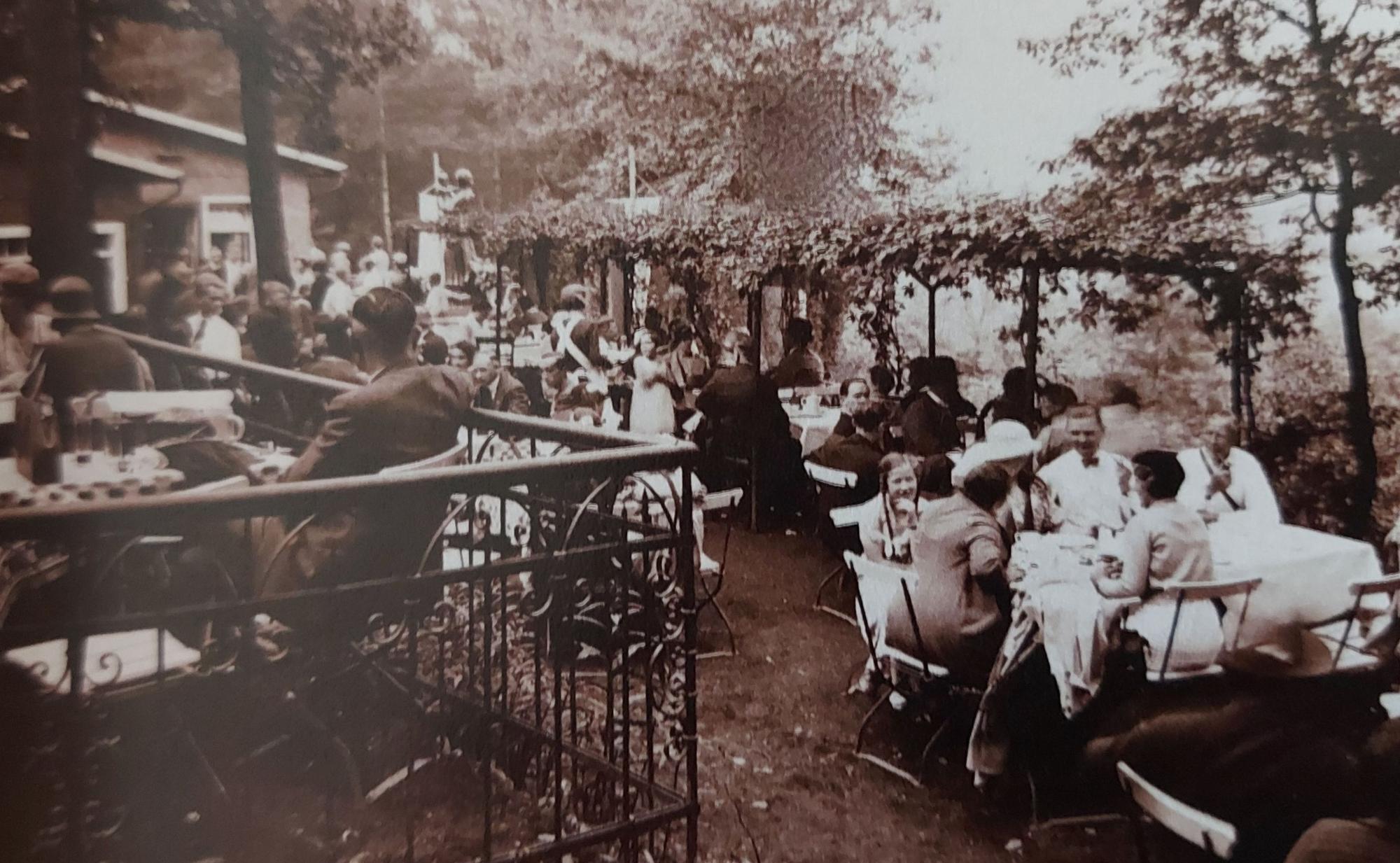 Ein sommerliches Gartenlokal mit vielen Familien an den Tischen.