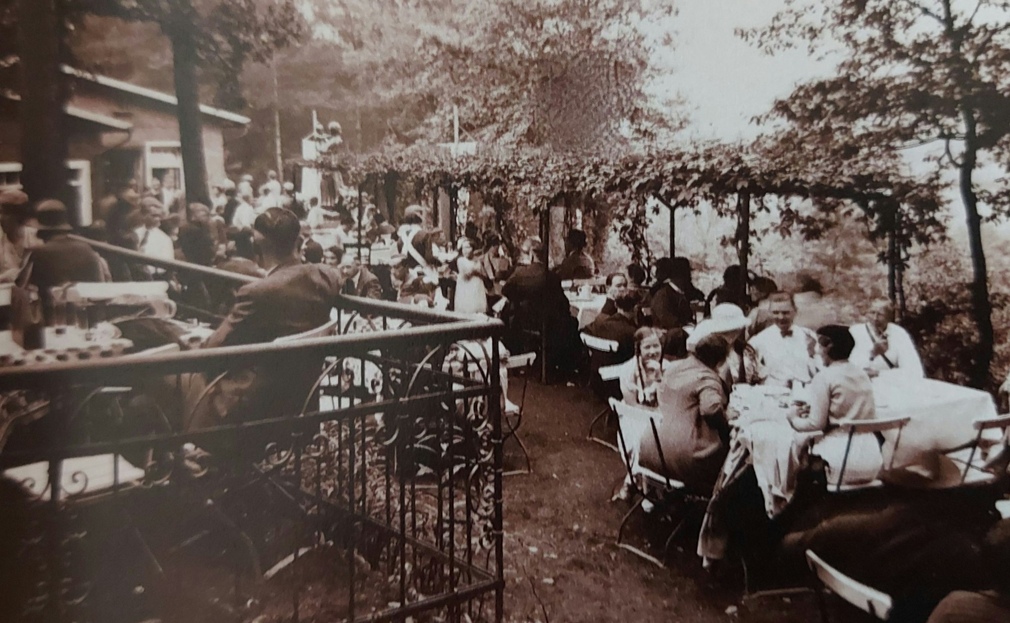 Ein sommerliches Gartenlokal mit vielen Familien an den Tischen.