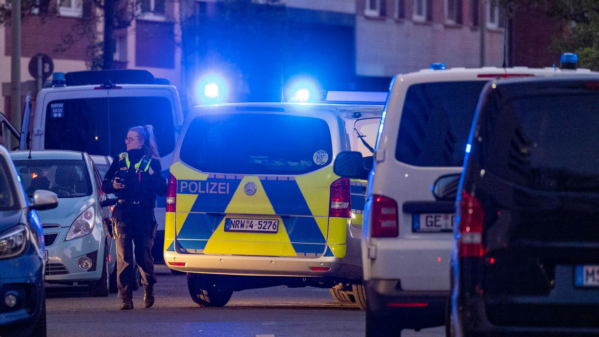 Eine Polizisten steht neben einem Polizeiwagen. (Symbolfoto)