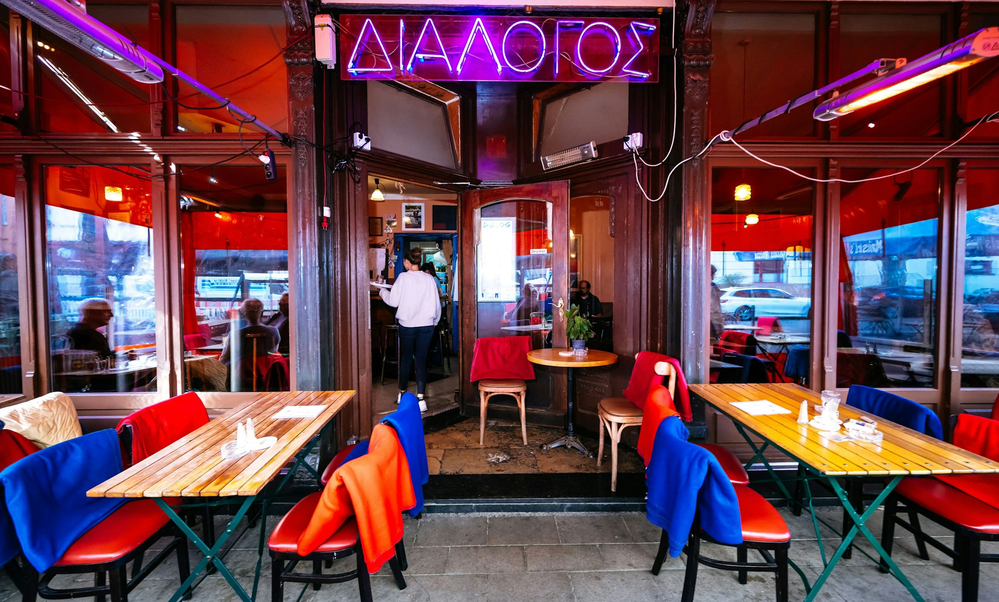 Tische stehen vor dem Eingangsbereich und auf den Stühlen liegen decken.