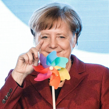 Dr. Angela Merkel dreht an einem Windrad.