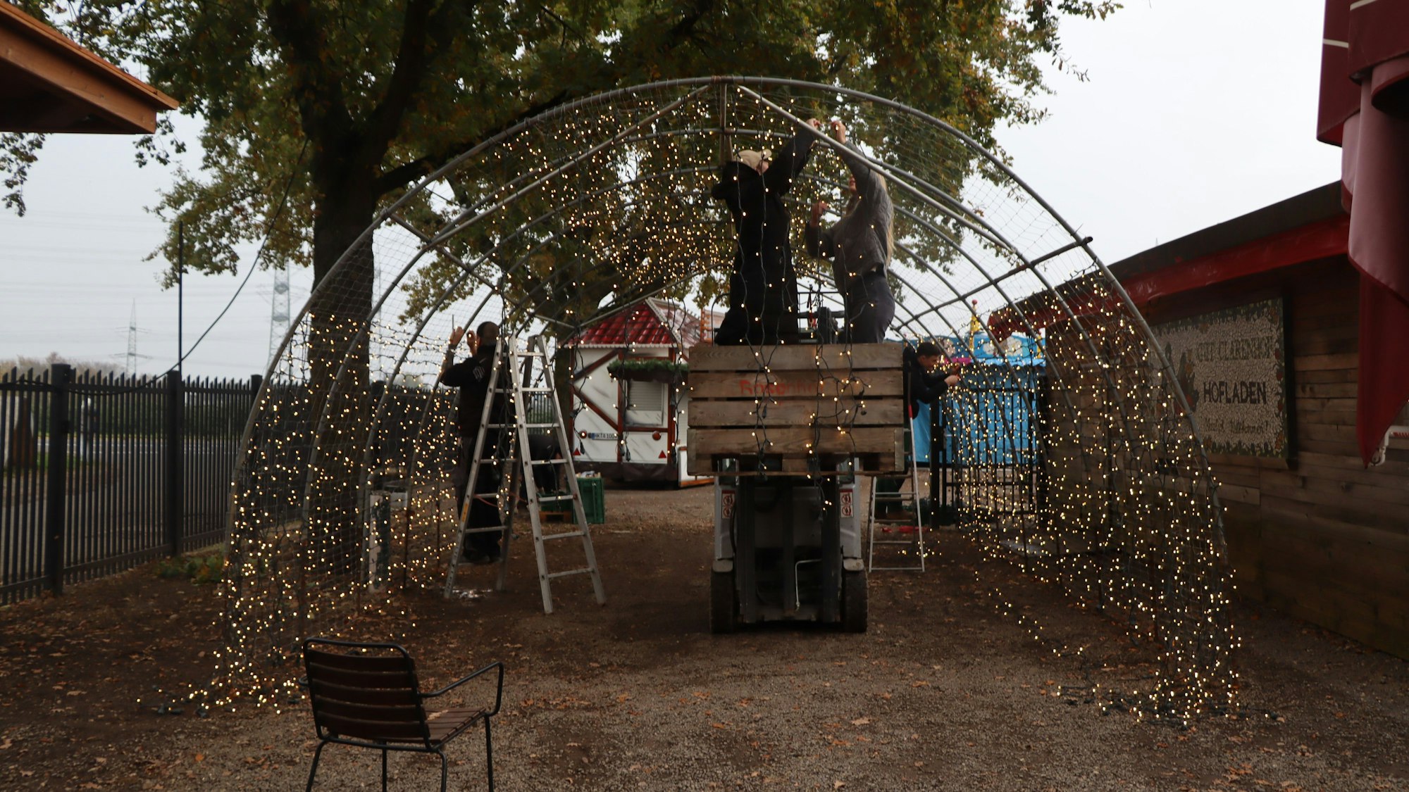 Auf dem Bild werden Lichterketten an ein Tunnelgerüst montiert.