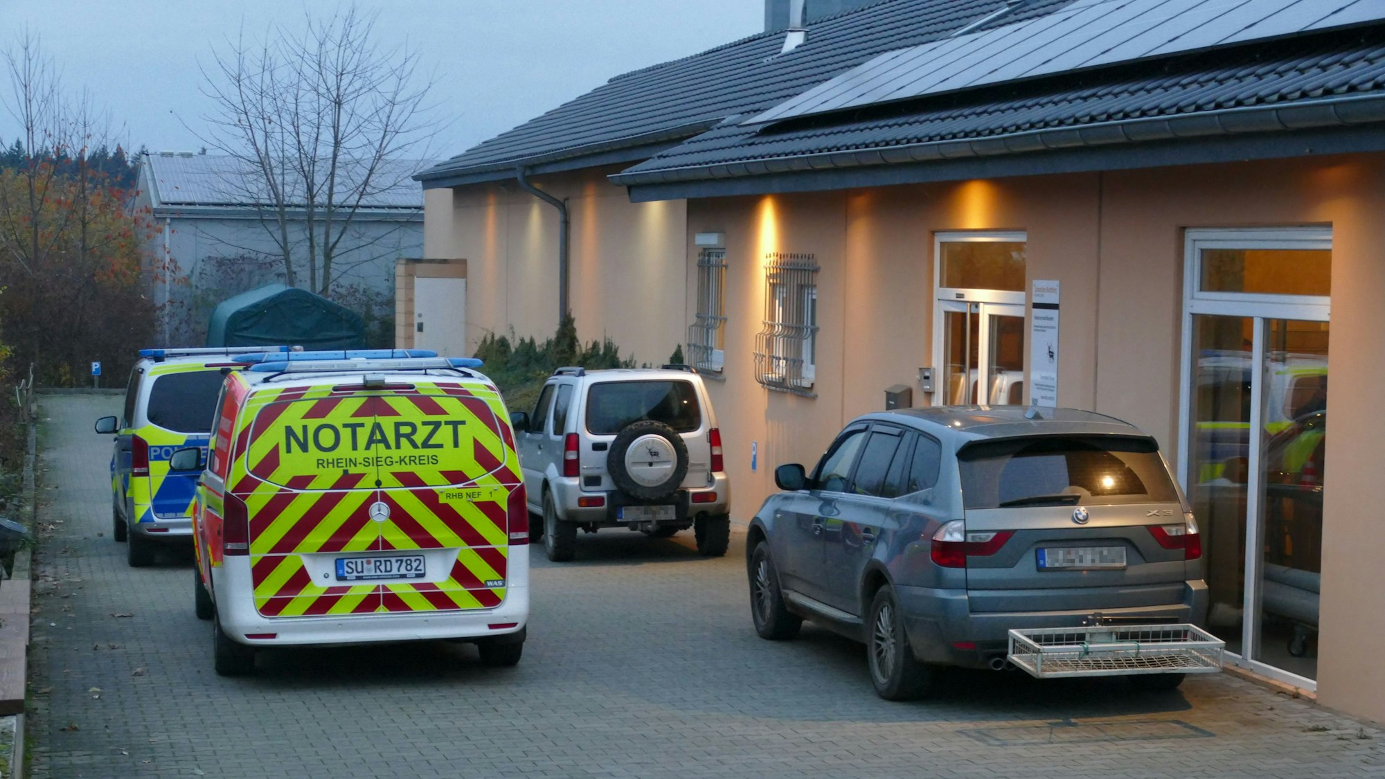 Polizei und Notarzt parken vor der Schießhalle an der Gimmersdorfer Straße.