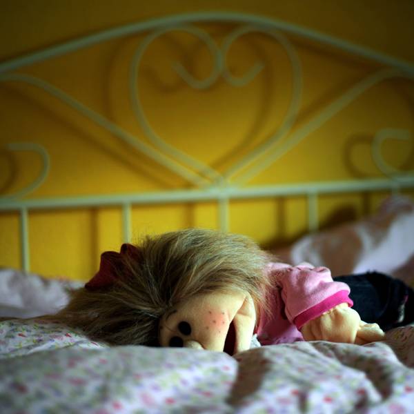 Eine Puppe liegt in Kassel in einem Kinderzimmer auf dem Bett.