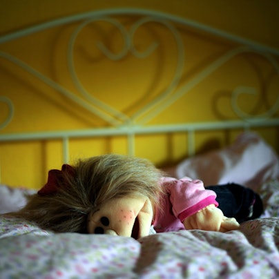 Eine Puppe liegt in Kassel in einem Kinderzimmer auf dem Bett.