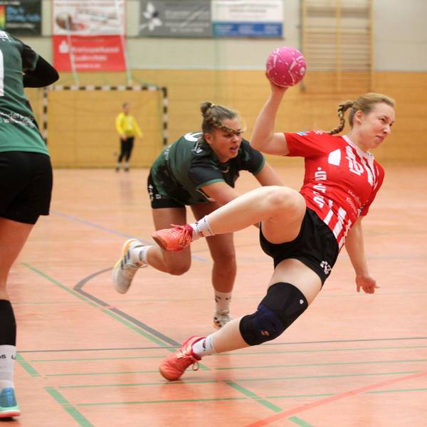 Eine Handballerin wirft den ganzen Körper in den Wurf und liegt schräg in der Luft.