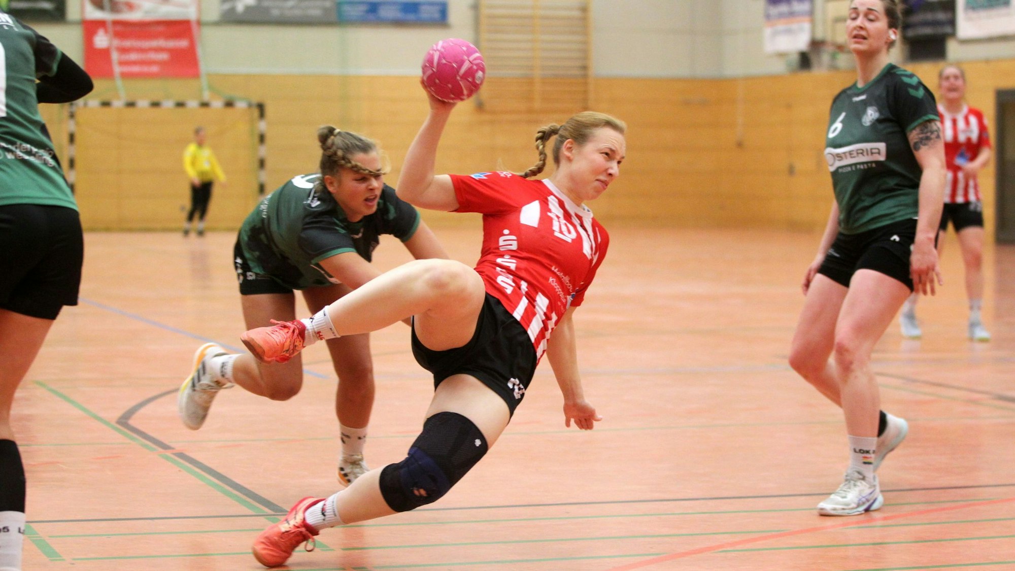 Eine Handballerin wirft den ganzen Körper in den Wurf und liegt schräg in der Luft.