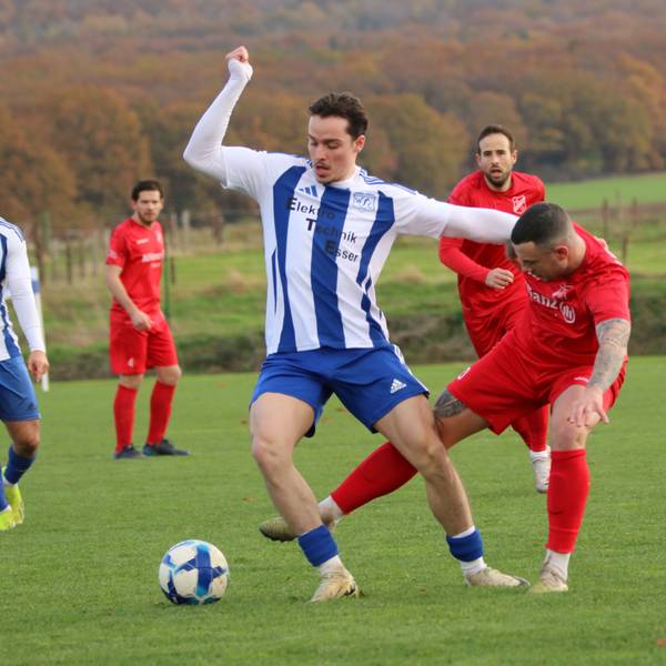 Mit dem Arm hält sich ein Fußballer den Gegenspieler vom Leib, der gleichzeitig von hinten versucht, an den Ball zu gelangen.