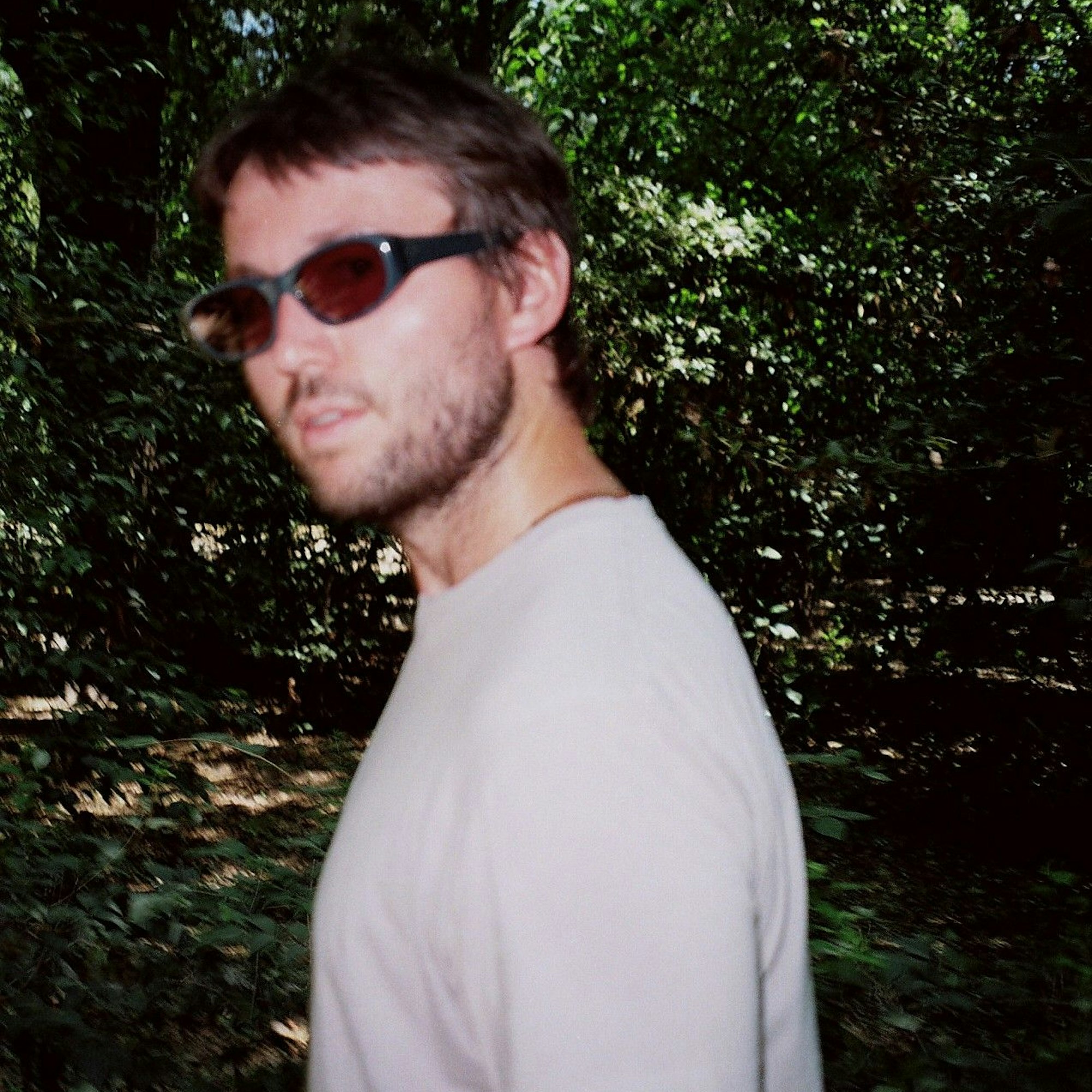 Der Musiker mit Sonnenbrille in einem Wald.