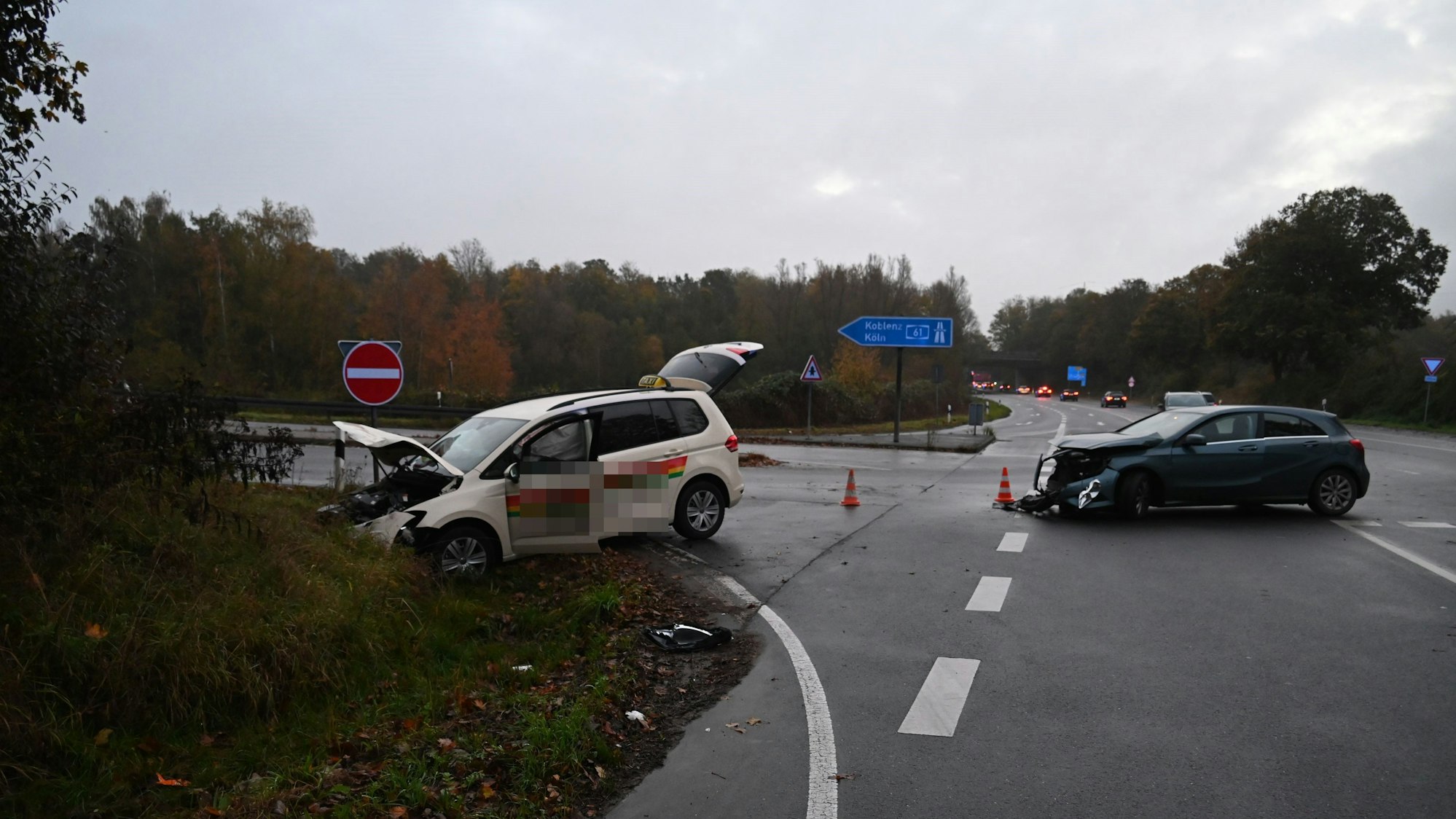 Zwei beschädigte Autos stehen auf einer Straße.