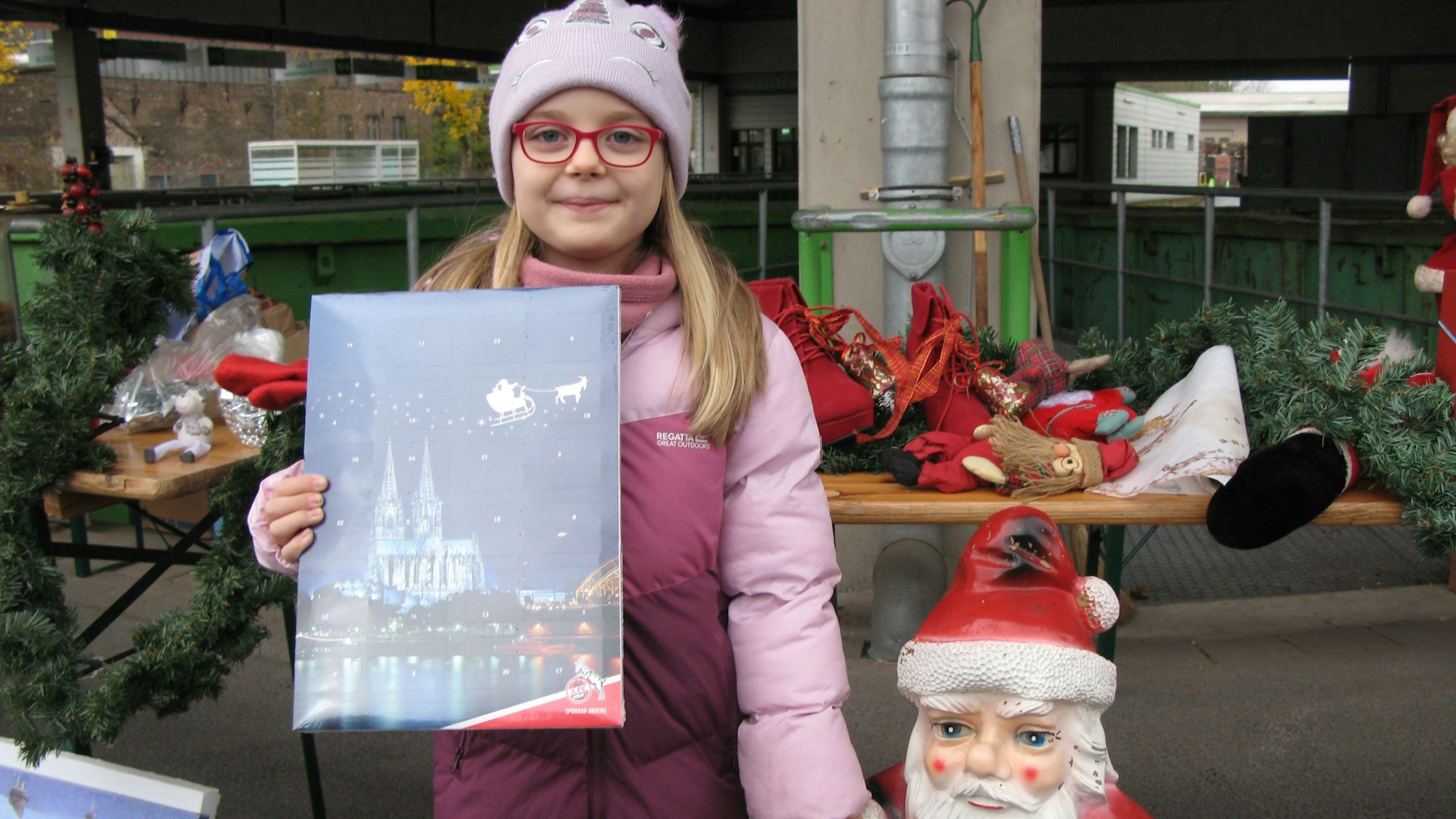 Ein kleines Mädchen mit einem Adventskalender.