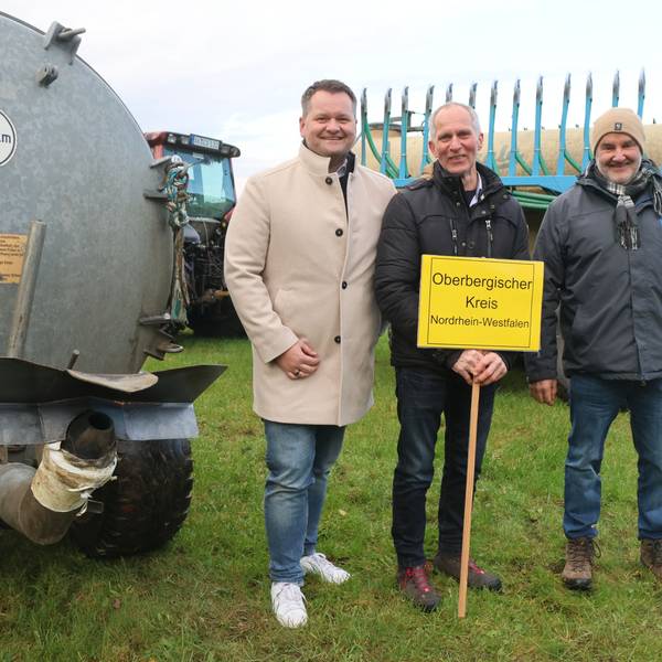 Christian Berger, Franz Bellinghausen und Bernd Schnippering zwischen einem Breitverteiler und einem Anhänger mit Schleppschuhsystem.