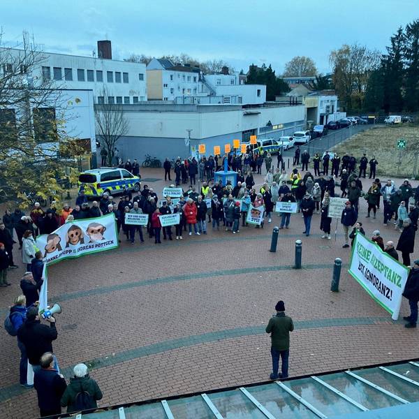 Auf dem Bild sind Demonstranten mit Transparenten vor dem Frechener Stadtsaal zu sehen.
