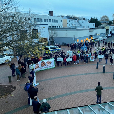 Auf dem Bild sind Demonstranten mit Transparenten vor dem Frechener Stadtsaal zu sehen.