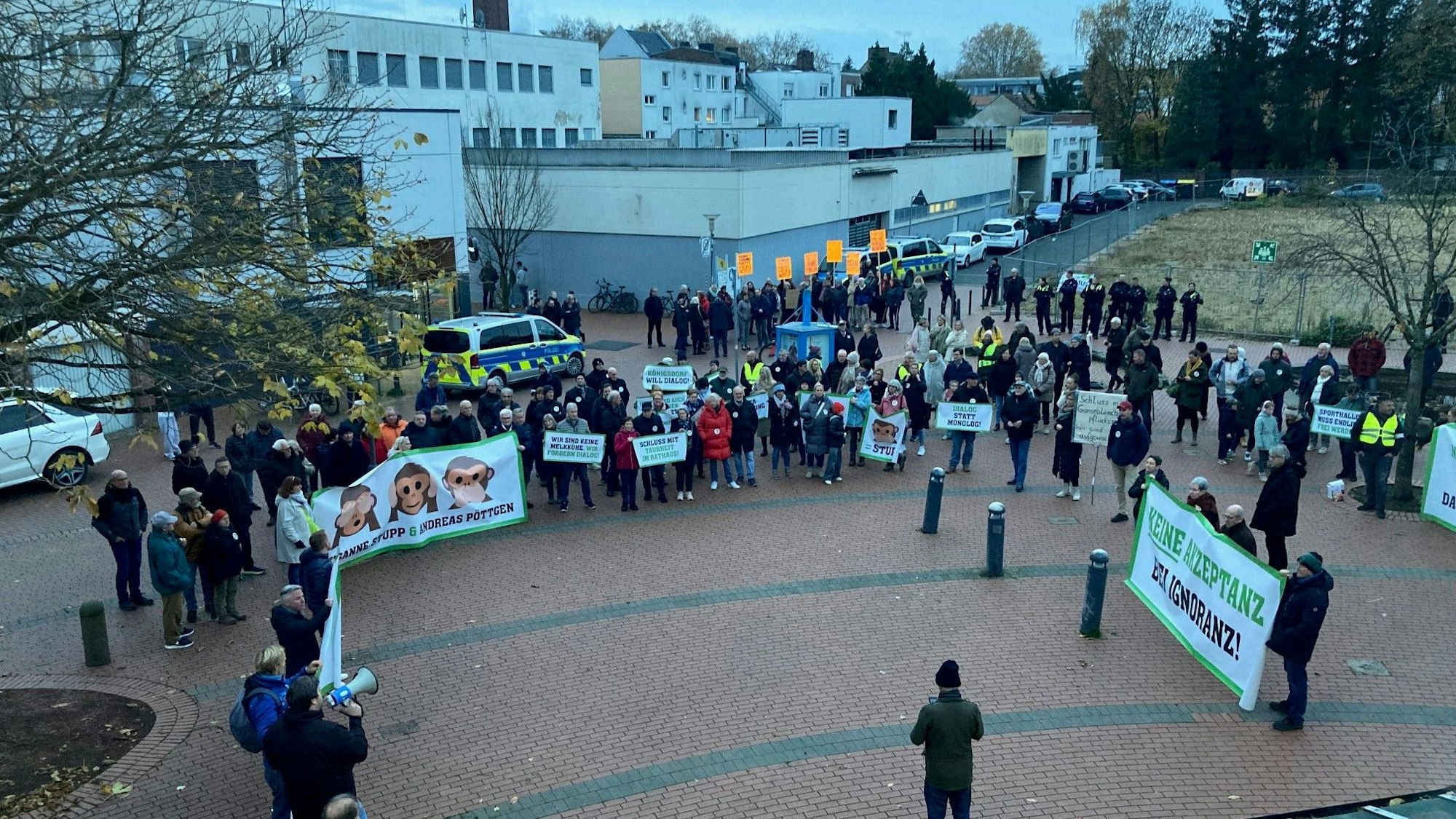 Auf dem Bild sind Demonstranten mit Transparenten vor dem Frechener Stadtsaal zu sehen.