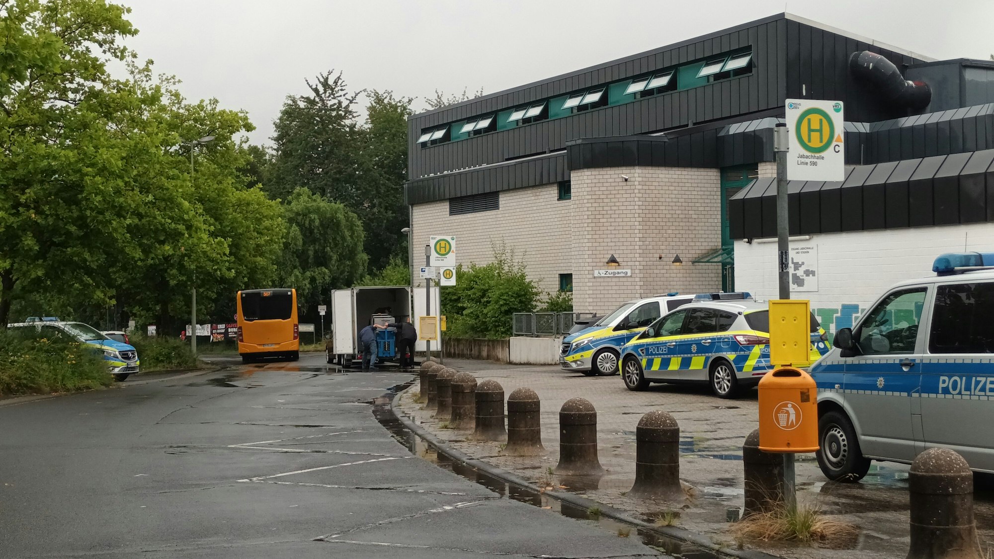Mehrere Streifenwagen stehen vor einer Versammlungshalle
