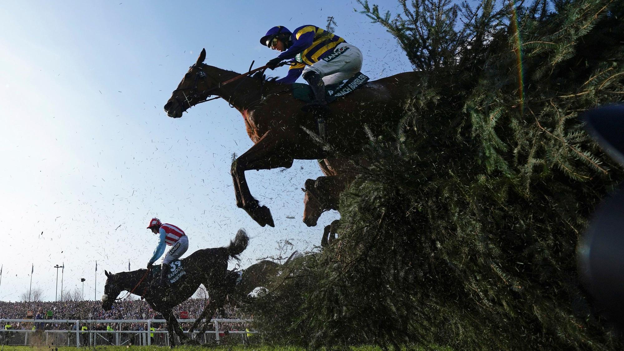 15.04.2023, Großbritannien, Liverpool: Derek Fox auf Corach Rambler (oben) überspringt auf dem Weg zum Sieg des Grand National Pferderennens auf der Aintree Rennbahn den Stuhlzaun.