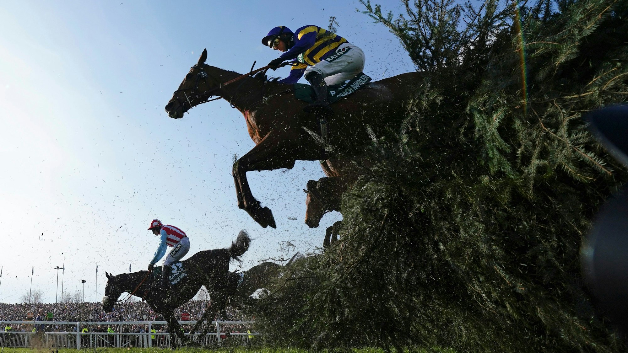 15.04.2023, Großbritannien, Liverpool: Derek Fox auf Corach Rambler (oben) überspringt auf dem Weg zum Sieg des Grand National Pferderennens auf der Aintree Rennbahn den Stuhlzaun.