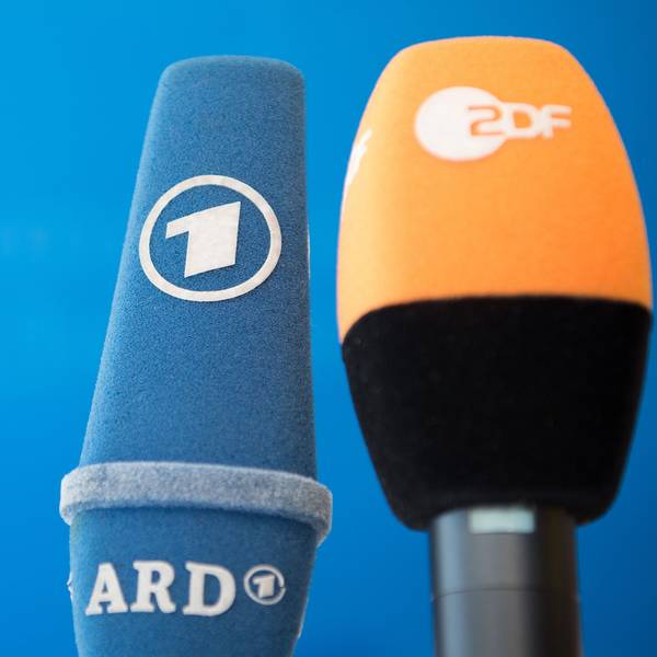 Die Mikrofone von ARD und ZDF sind vor einer Pressekonferenz nebeneinander aufgestellt.