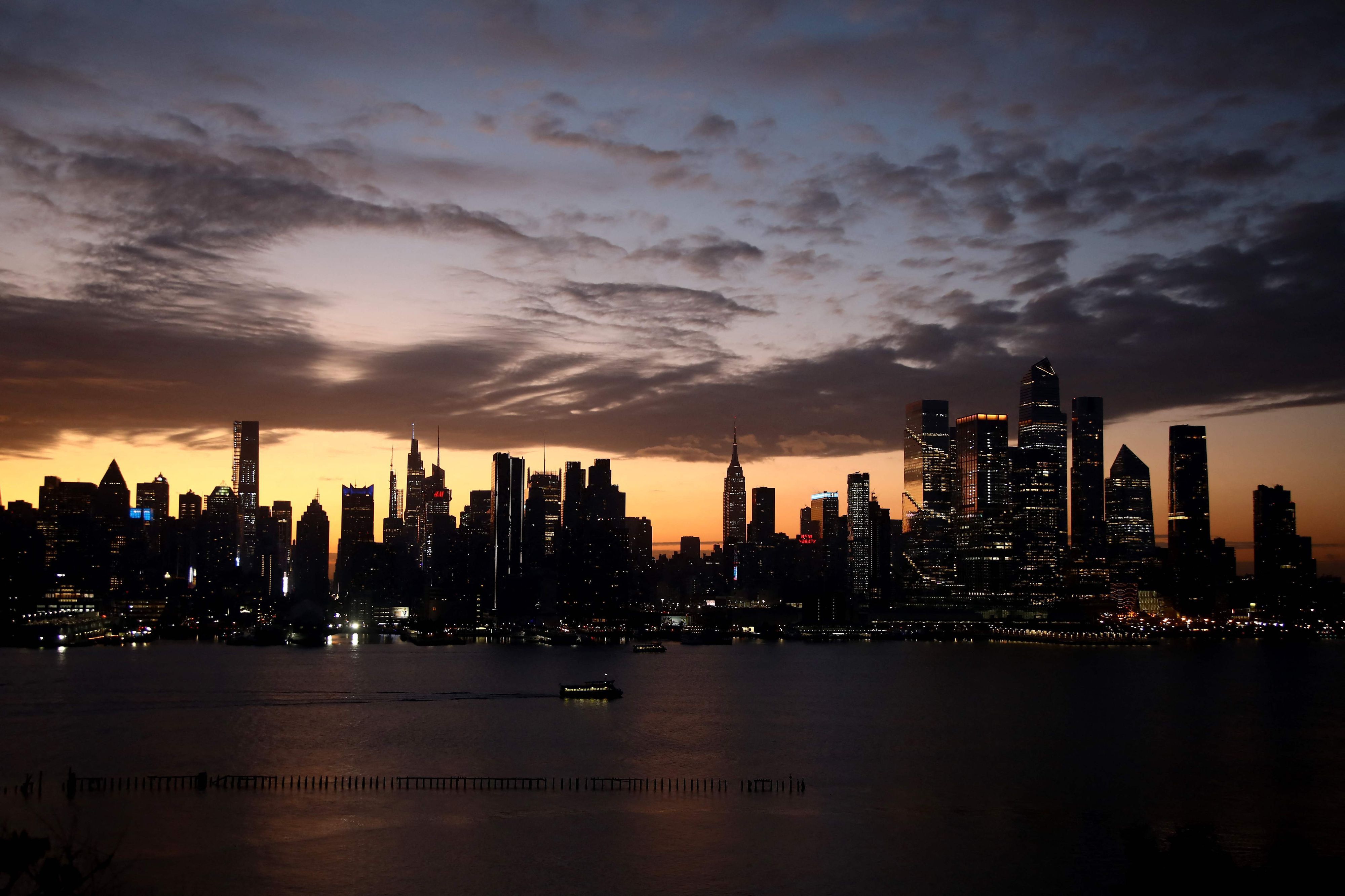 The sun rises behind the skyline of Manhattan in New York City on Election Day, as seen from Weehawken, New Jersey on November 5, 2024. (Photo by Leonardo Munoz / AFP)