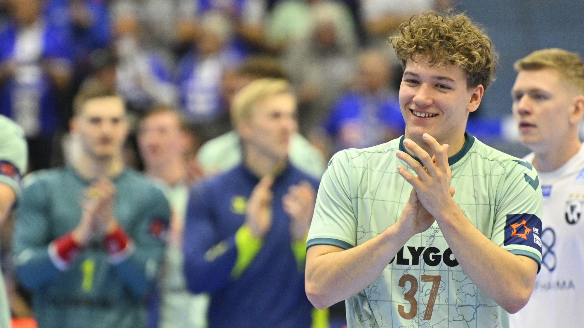 Tom Koschek applaudiert lachend dem Publikum.