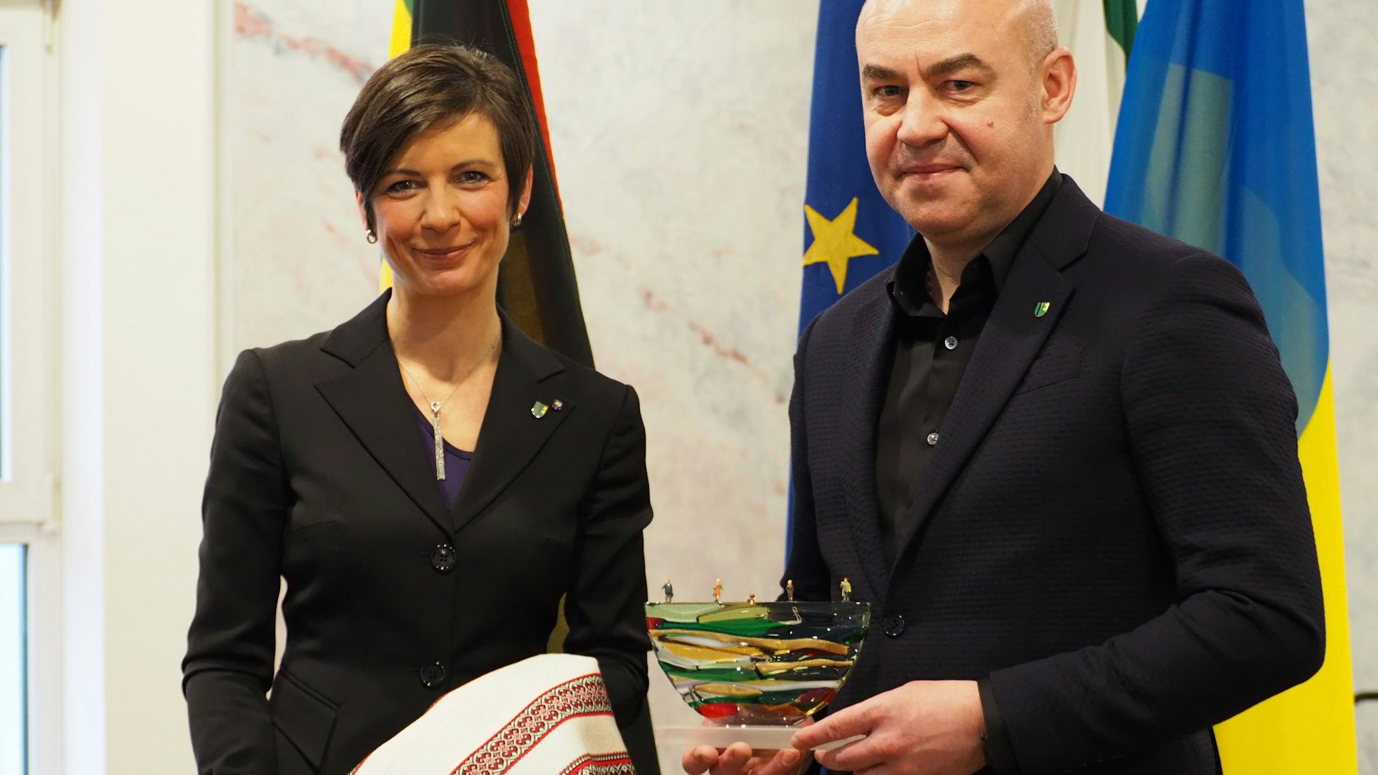 Zu sehen sind Carolin Weizel und Serhij Nadal, die Gastgeschenke austauschen.