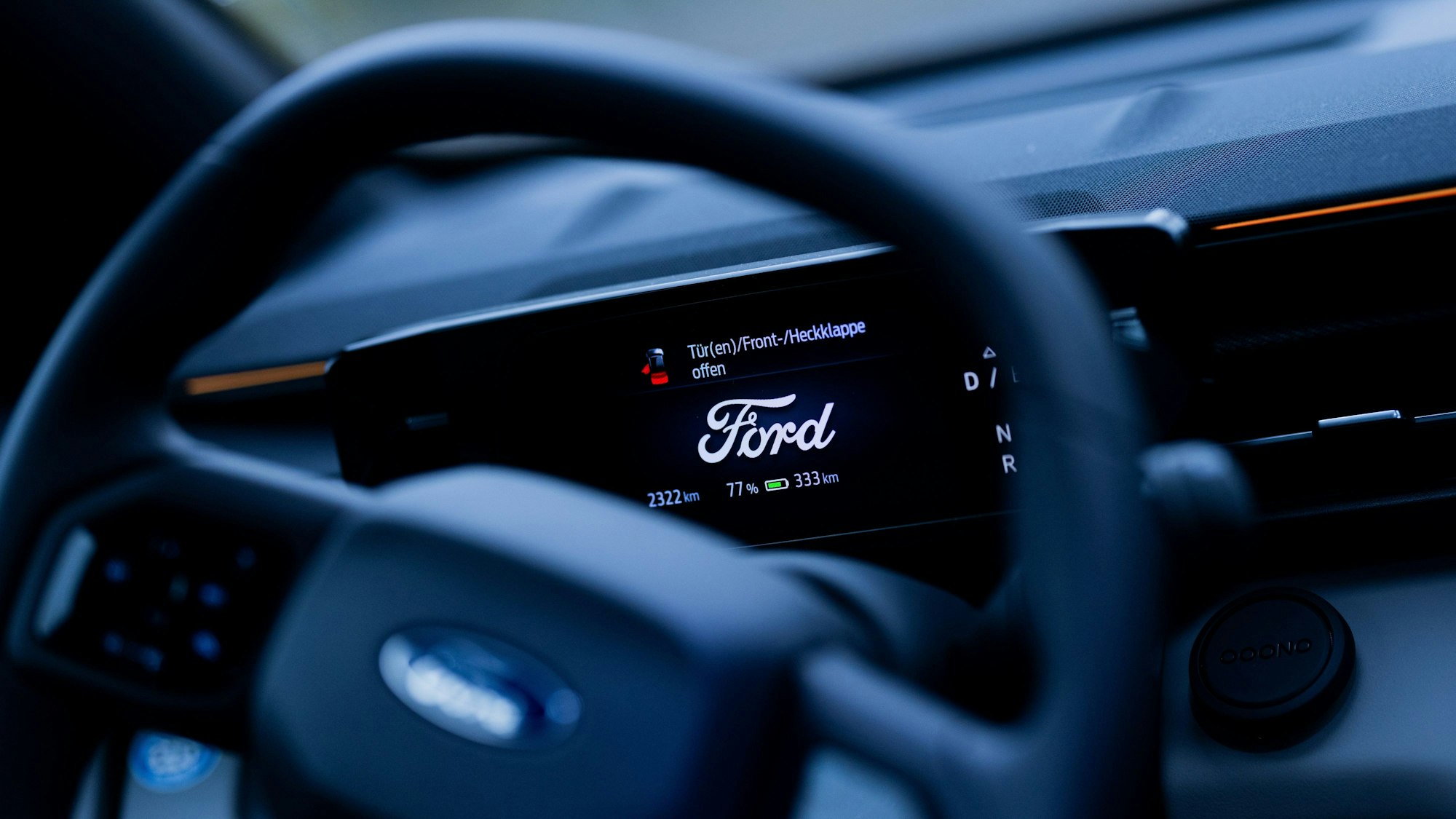 20.11.2024, Nordrhein-Westfalen, Köln: Das Logo von Ford leuchtet im Display eines Elektroauto vom Typ Explorer auf dem Werksgelände der Ford-Werke in Köln-Niehl. +