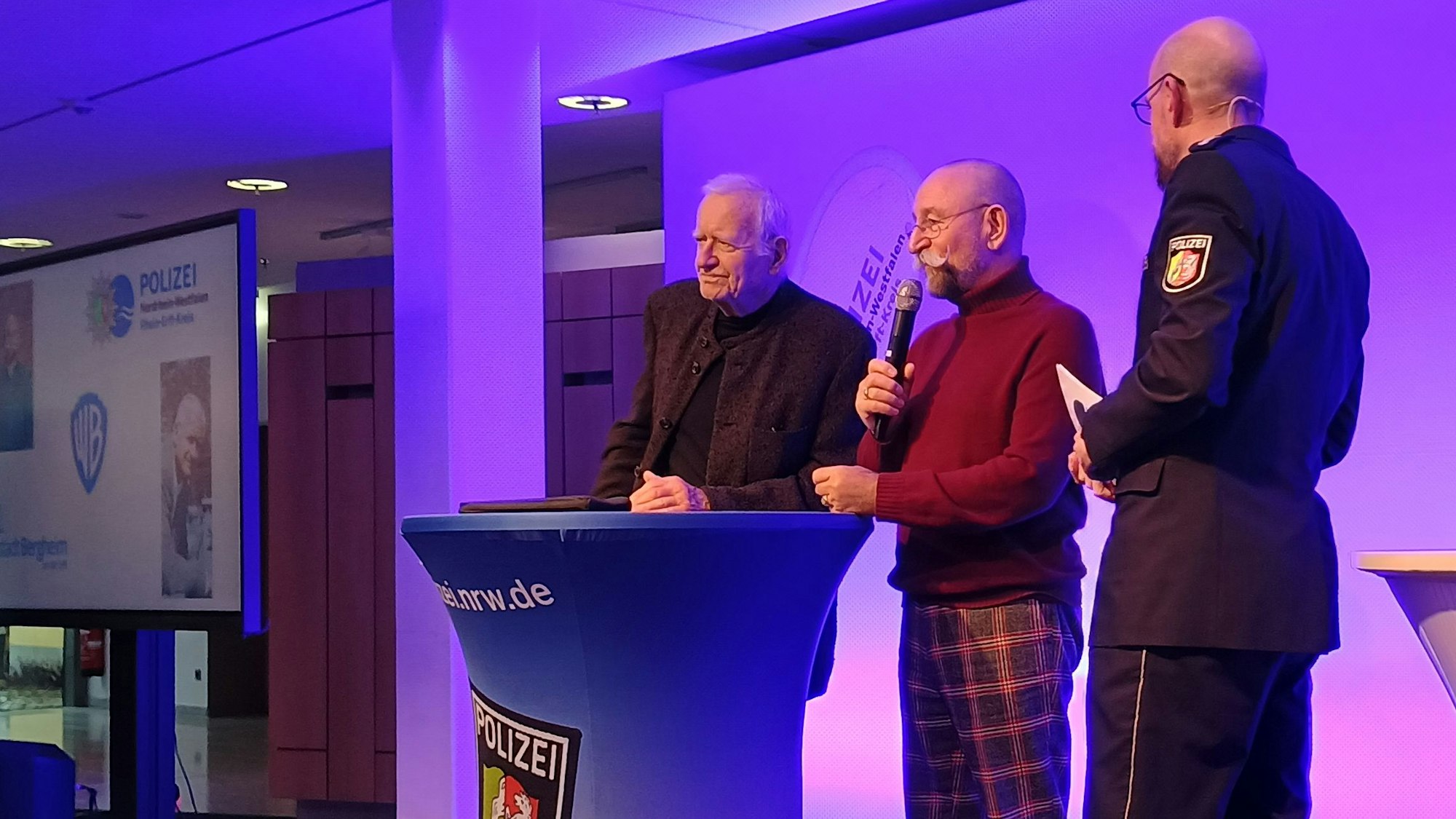 Bongart und Lichter stehen auf der Bühne des Medio Rhein Erft neben einem Pressesprecher der Polizei.