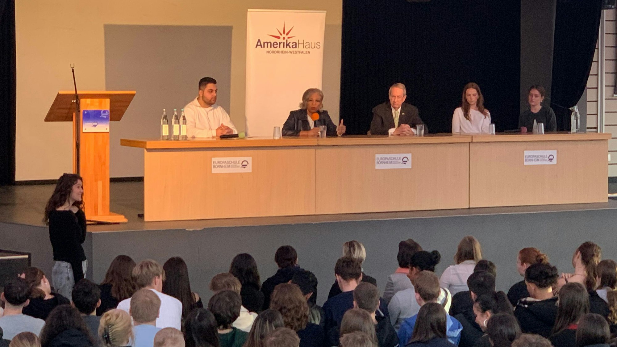 Die ehemaligen US-Kongressabgeordneten Brenda Lawrence und Bob Goodlatte (auf dem Podium, 2. und 3. v.l.) besuchten die Europaschule Bornheim. Schüler moderierten das Gespräch.