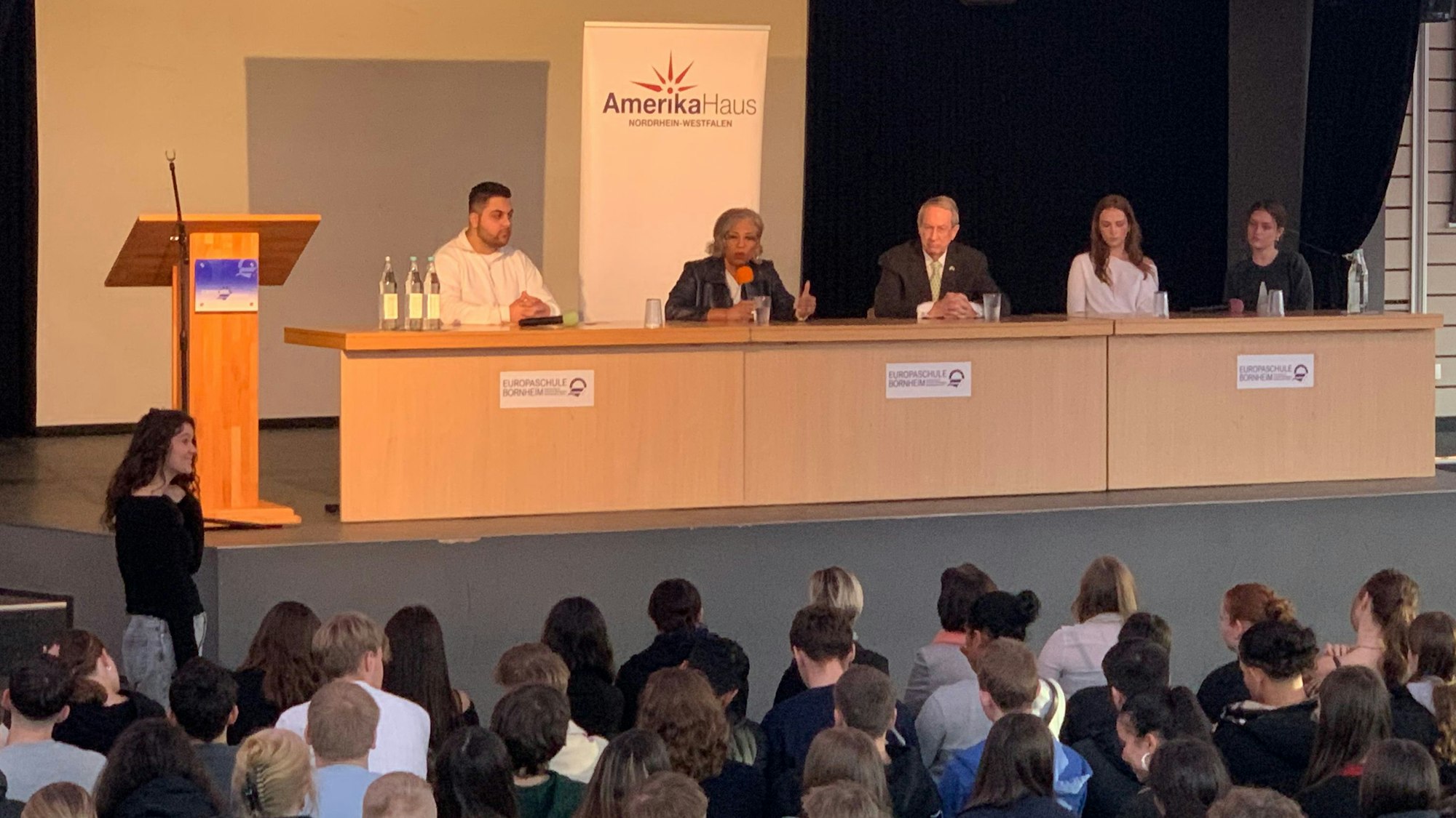 Die ehemaligen US-Kongressabgeordneten Brenda Lawrence und Bob Goodlatte (auf dem Podium, 2. und 3. v.l.) besuchten die Europaschule Bornheim. Schüler moderierten das Gespräch.