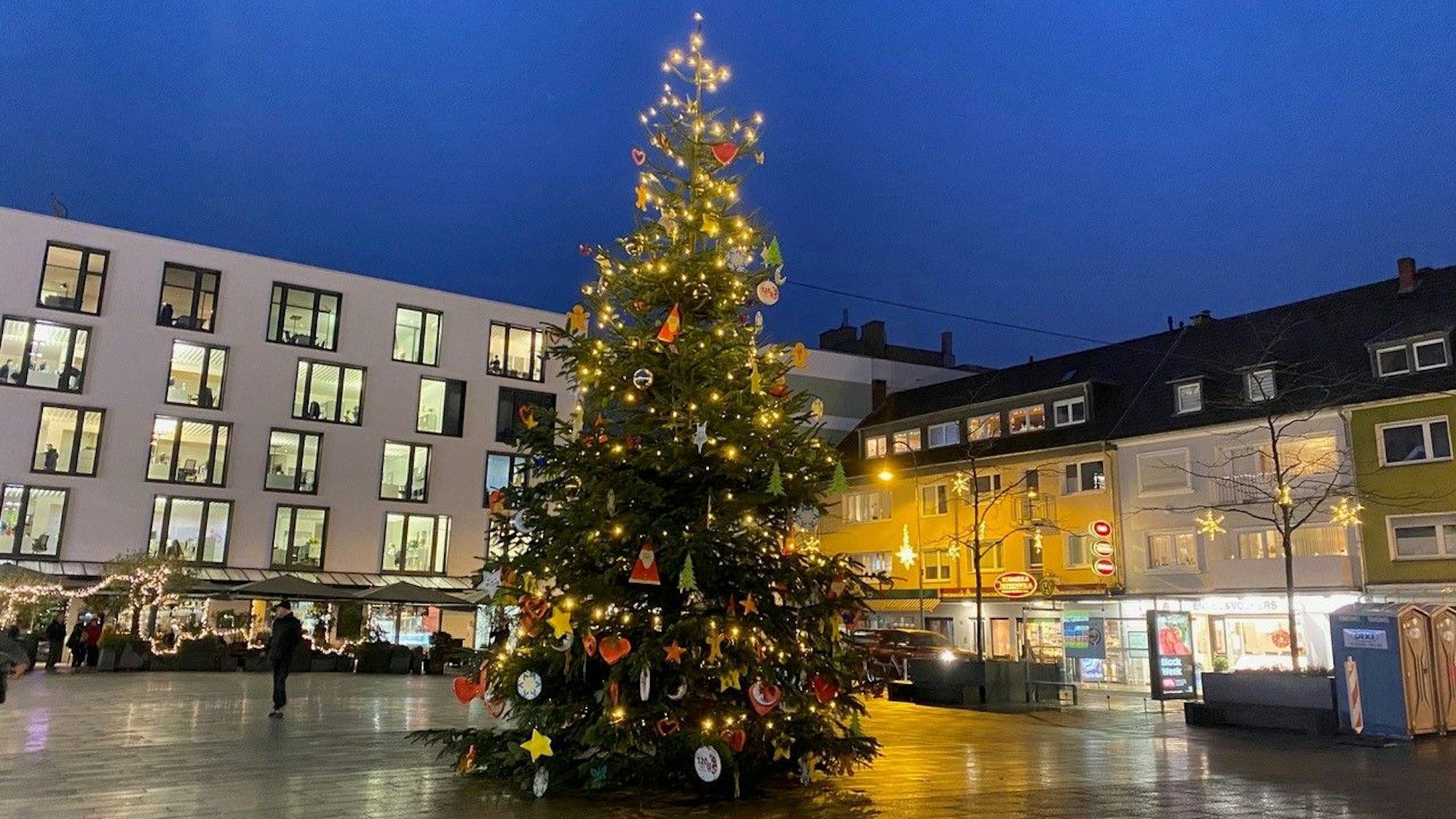 Ein geschmückter Weihnachtsbaum steht auf dem Maternusplatz in Rodenkirchen.