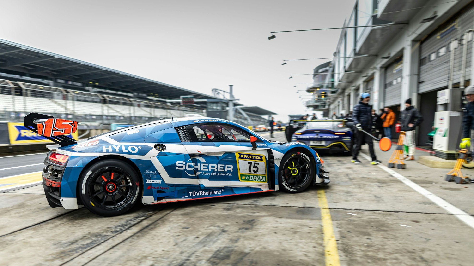 Ein Audi fährt in die Box, der Hintergrund verschwimmt leicht durch die Bewegungsunschärfe.