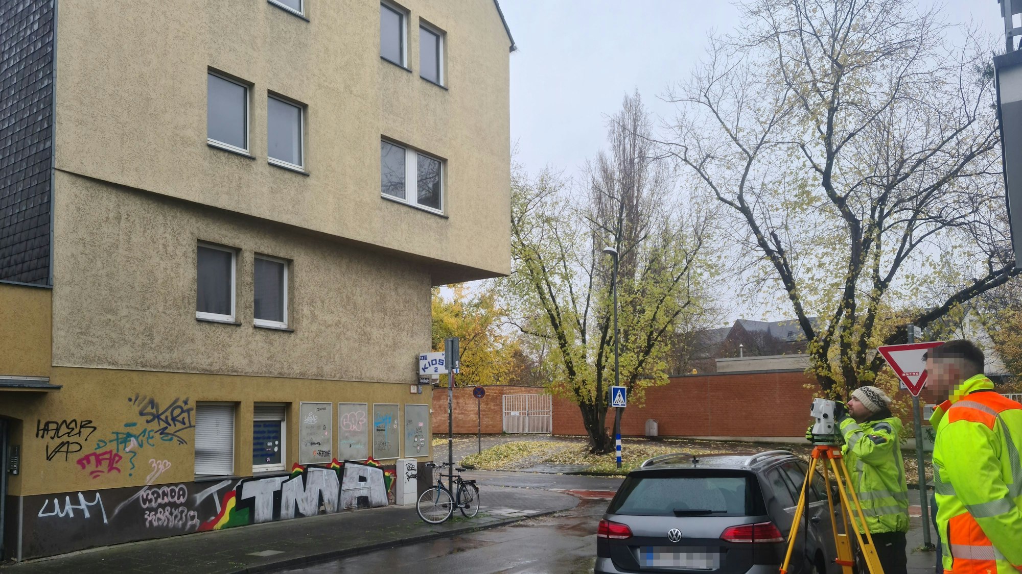 Blick auf eine T-Kreuzung, an der ein sehr großes gelbes heruntergekommenes Haus steht.