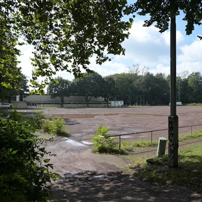 Auf dem brach liegenden Aschenplatz stehen Pfützen.