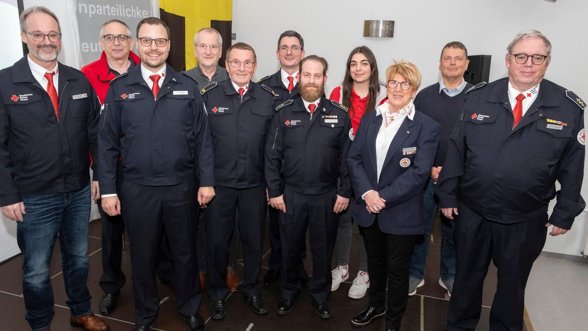 Menschen haben sich in einem Innenraum für ein Foto als Gruppe aufgestellt.