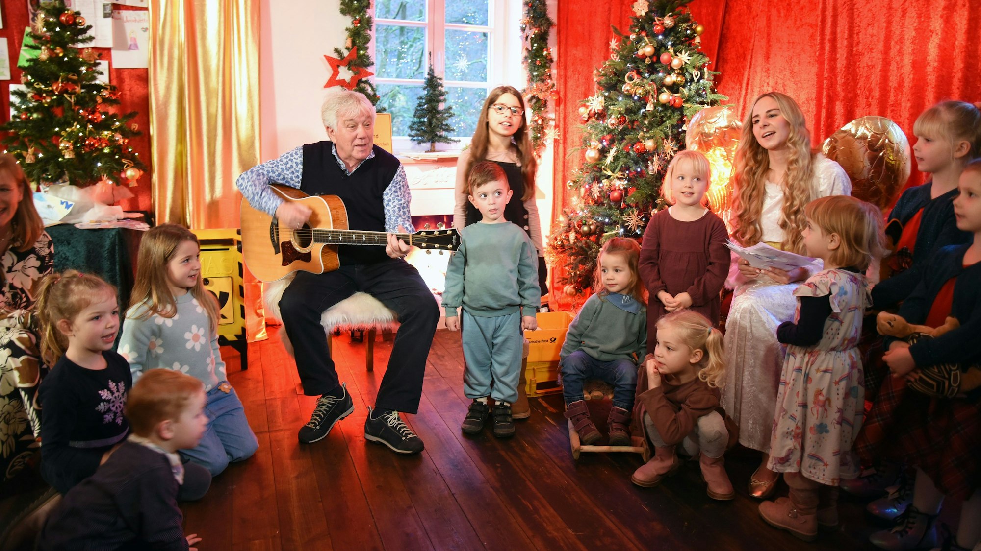 Der Liedermacher Rolf Zuckowski singt mit dem Christkind und vielen kleinen Kindern.