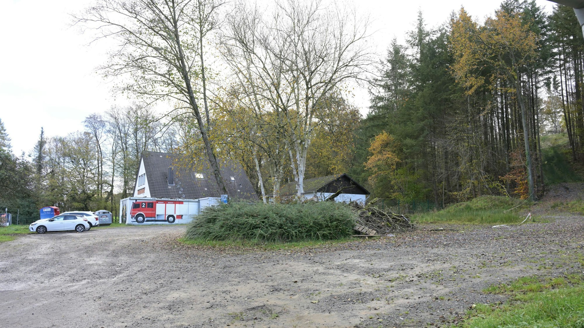 Ein Wanderparkplatz, dahinter ein Feuerwehrhaus.