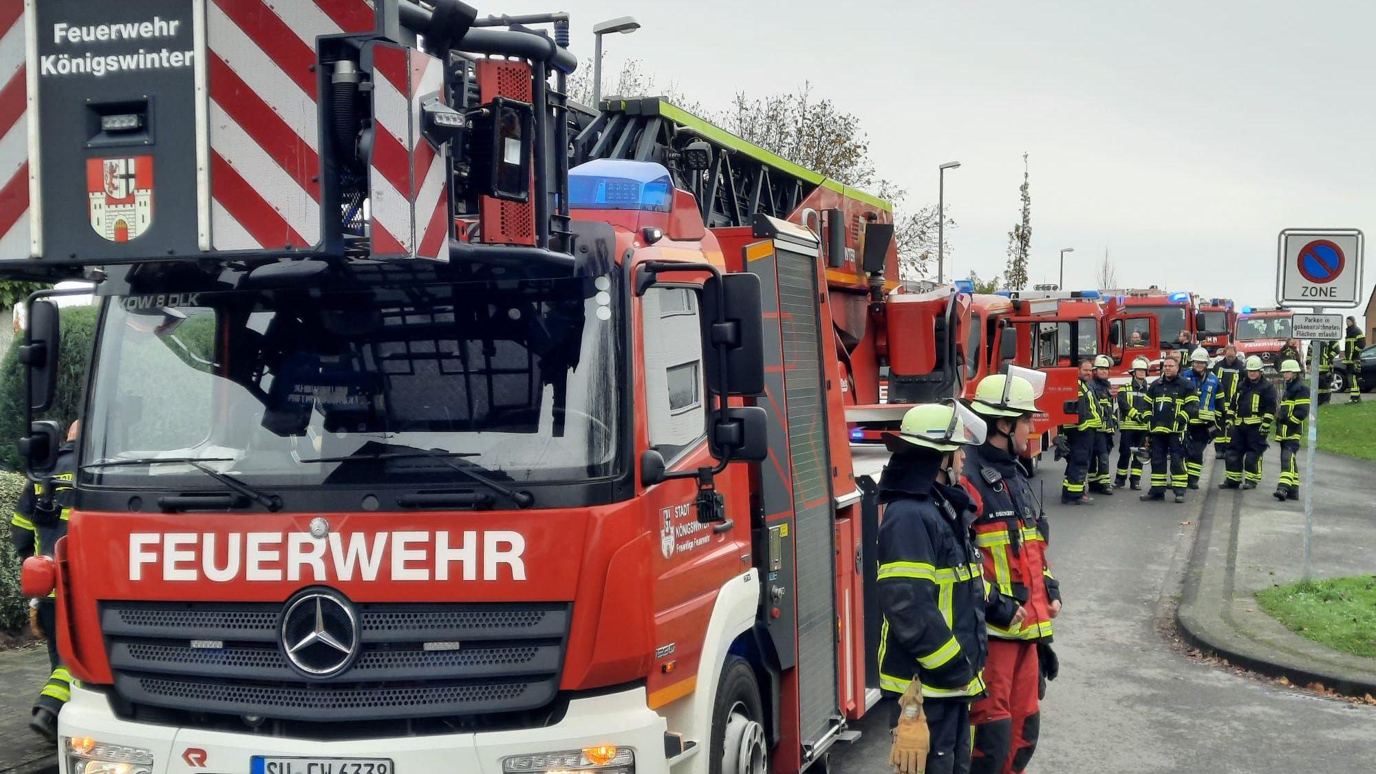 Hinter der Drehleiter stehen zahlreiche Fahrzeuge der Feuerwehr.