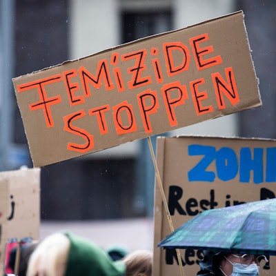 Bei einer Demonstration gegen Gewalt an Frauen hält eine Teilnehmerin ein Plakat mit der Aufschrift „Femizide stoppen“.