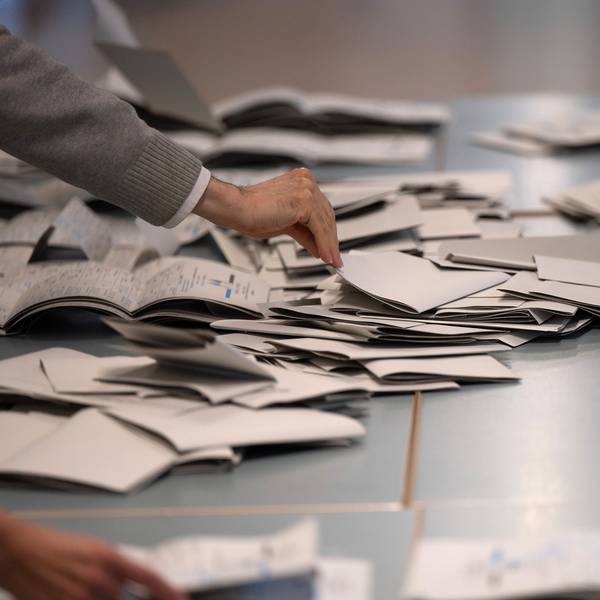 Wahlhelfer und Wahlhelferinnen zählen in einem Wahllokal Stimmzettel für die Bundestagswahl aus.
