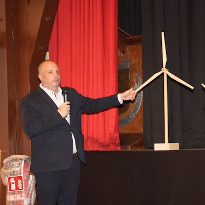 Bergneustadts Bürgermeister Matthias Thul demonstriert das Größenverhältnis der neuen Windräder im Vergleich zu bestehenden Gebäuden