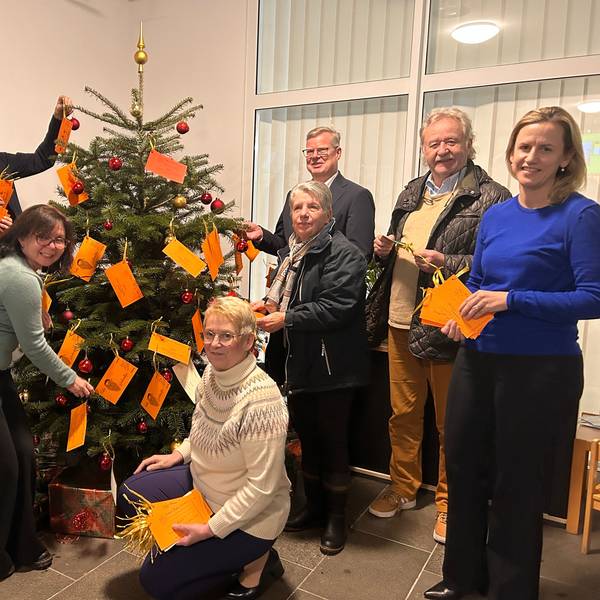 Bürgermeister Dirk Runge, Tenneco-Geschäftsführer Thomas Ebker und Annika Wiertz, Sprecherin von Adient stehen an einem Weihnachtsbaum.