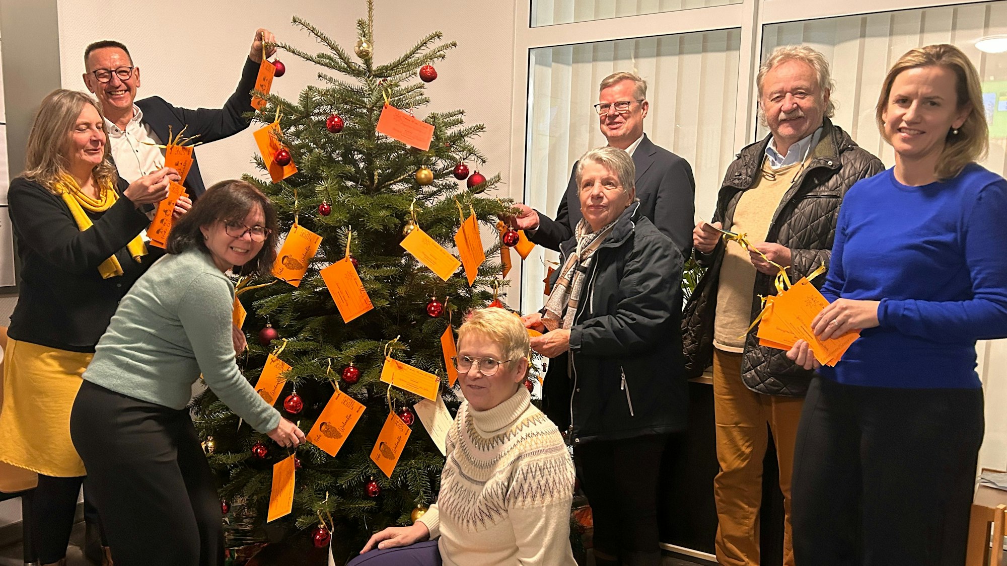Bürgermeister Dirk Runge, Tenneco-Geschäftsführer Thomas Ebker und Annika Wiertz, Sprecherin von Adient stehen an einem Weihnachtsbaum.