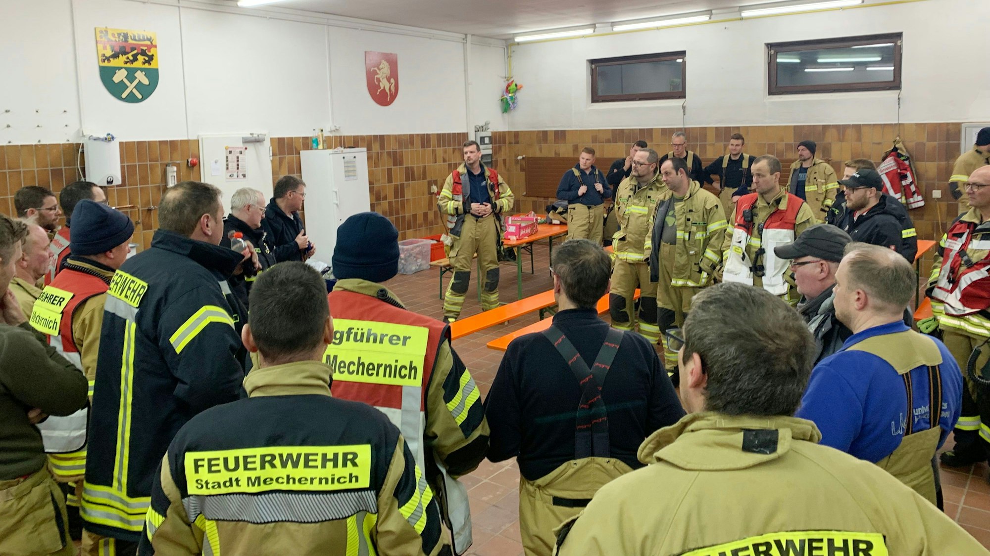 Feuerwehrleute besprechen sich im Feuerwehrgerätehaus.