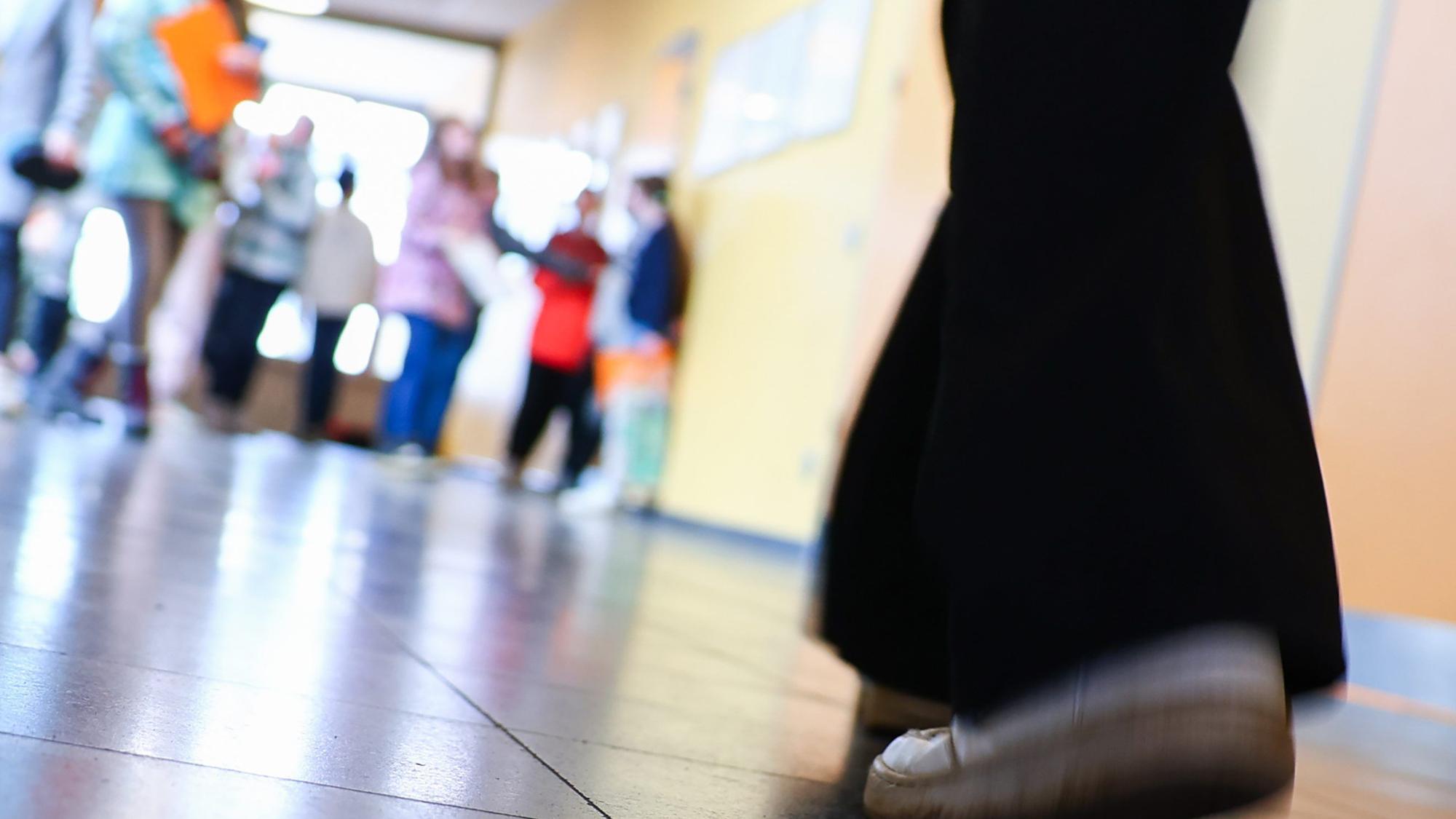 Schüler gehen durch einen Gang zu ihrem Klassenzimmer. (Symbolbild)