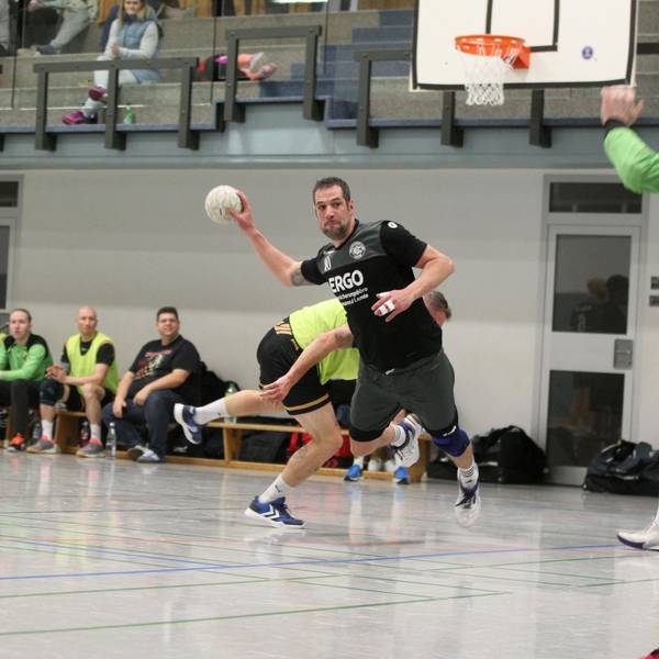Simon Wilms beim Wurf auf das Tor, im Hintergrund schauen andere Spieler zu.