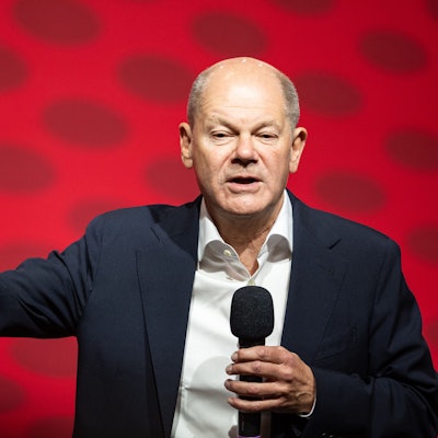 Olaf Scholz bei einer Rede, mit Mikrofon in der Hand.