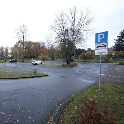 Eine große Parkplatzfläche mit nur vier geparkten Fahrzeugen.