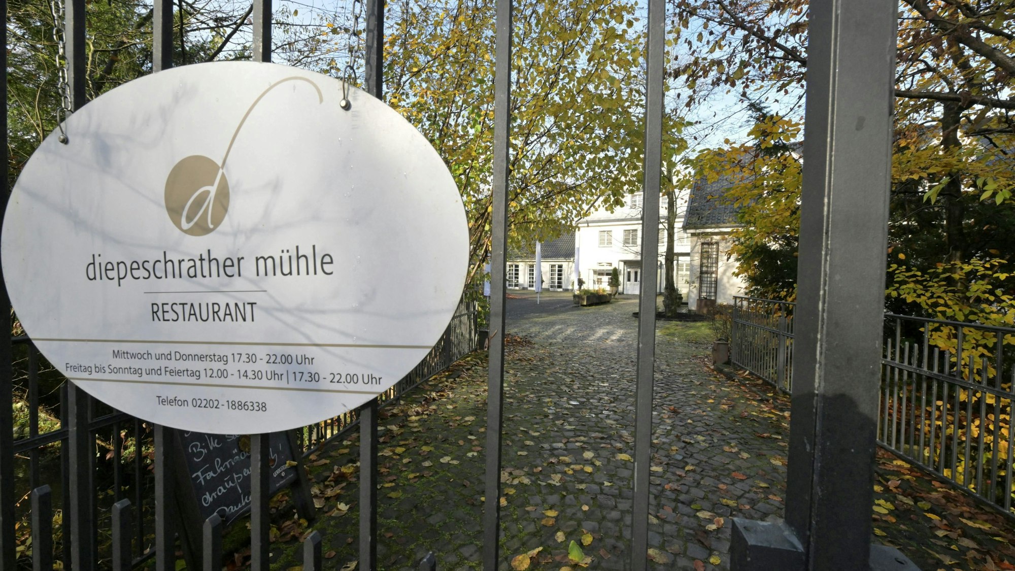 Blick auf die Diepeschrather Mühle durch das Gitter eines Tores.